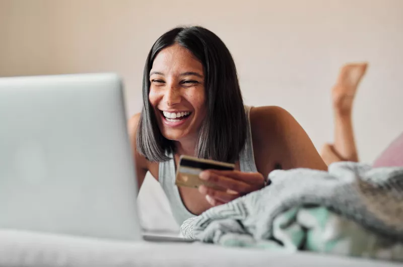 Girl laptop credit card payment bed ecommerce laughing banking app website female person finance transaction online shopping fintech investment planning sale